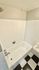 Modern bathroom with elegant white tile walls and stylish black-and-white checkered floor.
