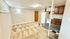 Cozy apartment interior featuring a carpeted living area adjacent to a compact kitchen with wooden cabinets and modern appliances.