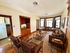 Inviting living room with elegant leather seating, warm wooden accents, and ample natural light from large windows.
