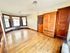 Inviting room with gleaming hardwood floors, elegant wood cabinetry, and bright natural light from multiple windows.