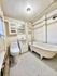 Charming bathroom with vintage clawfoot tub, modern sink, and cozy lighting, featuring classic hexagonal floor tiles.