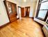 Charming room with polished hardwood floors, vintage wooden cabinetry, and large bright windows.