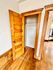 Charming interior showcasing a classic wooden closet door with warm wood flooring, adding a cozy touch to the room.