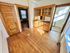 Charming apartment with vintage wooden built-in shelving and doors, showcasing beautiful hardwood floors bathed in natural sunlight.