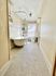 Bright and spacious bathroom featuring a classic clawfoot tub, vintage-style hexagon tile flooring, and ample natural light from a large window.