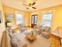 Bright and inviting living room with cozy beige seating, hardwood floors, and large windows offering city views.
