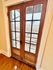 Charming wooden French doors opening out to a picturesque urban view with historic architecture.