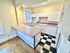Charming kitchen featuring a retro black-and-white checkered floor, cozy breakfast bar, and ample natural light with modern white cabinetry.