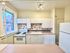 Charming kitchen with vintage stove, bright natural light, white cabinetry, and classic tiles.
