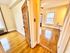 Bright and inviting apartment interior with gleaming hardwood floors, large windows, and open doorways.