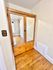 Charming wooden mirrored wardrobe with ample drawer storage on polished hardwood floors.