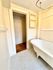 Charming bathroom featuring a classic clawfoot tub, stylish hexagonal floor tiles, and convenient built-in shelving.