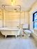 Charming vintage bathroom featuring a classic clawfoot tub, elegant pedestal sink, and large window providing natural light.