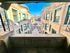 Charming courtyard view from a balcony overlooking a historic brick apartment building with decorative details and vibrant windows.