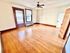 Bright and inviting room with elegant hardwood floors, classic wooden trim, and large windows letting in natural light.