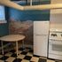 Charming kitchen with vintage checkered flooring, exposed brick wall, and modern appliances.