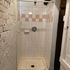 Charming shower area with classic white and pink tiles, featuring a sleek modern design perfect for cozy apartment living.
