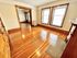 Charming apartment showcasing polished hardwood floors, large windows with blinds, and elegant wood trim.