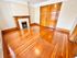 Elegant room with polished hardwood floors, double wooden doors, and a classic fireplace, exuding warmth and charm.