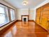 Charming room with polished wood floors, a cozy fireplace, and large windows offering abundant natural light.