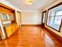 Bright and inviting room with polished hardwood floors, built-in wooden cabinetry, and large windows for natural light.