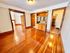 Inviting apartment interior with gleaming wooden floors, built-in cabinetry, and open doorways leading to a cozy kitchen and living area.