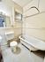Charming vintage bathroom featuring a classic clawfoot tub, hexagonal tile flooring, and elegant fixtures.