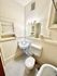 Bright and compact bathroom with vintage charm, featuring classic fixtures and elegant tile flooring.