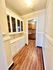 Charming hallway with elegant built-in cabinets and warm wood flooring leading to a cozy kitchen space.