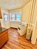 Cozy kitchen nook with gleaming hardwood floors, classic gas stove, and bright windows offering natural light.