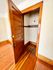 Charming wooden closet with classic door, featuring elegant wood flooring, perfect for stylish storage solutions.