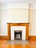 Charming room with a classic wooden mantle and elegant fireplace, showcasing warm hardwood floors and vintage appeal.