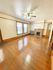 Charming living room with polished hardwood floors, large windows, built-in fireplace, and ceiling fan.