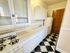Charming kitchen with vintage black and white checkered flooring, classic white cabinetry, and a cozy layout.