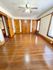 Bright, spacious room featuring polished hardwood floors, multiple wooden doors, and a ceiling fan, ideal for various living arrangements.