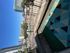 Charming apartment balcony with colorful geometric rug, offering urban skyline views and modern city living ambiance.