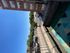 Charming city view from a cozy balcony with vibrant geometric rug and a clear blue sky.