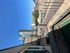Charming urban balcony with cityscape view, showcasing modern high-rise buildings under a clear blue sky.