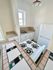 Charming cozy kitchen featuring a tiled countertop, gas stove, and natural light from a window.
