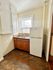 Cozy kitchen featuring elegant white cabinets, polished countertops, and a large window for natural light.