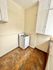 Charming kitchen nook featuring a cozy white gas stove and ample cupboard space, ideal for compact cooking solutions.