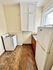 Cozy kitchen with charming wooden cabinetry, natural light from a large window, and classic tile flooring, offering a warm and inviting cooking space.