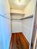 Spacious walk-in closet with elegant wooden floors and ample shelving, perfect for organized storage.
