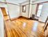 Bright room with gleaming hardwood floors, freshly painted walls, and large windows inviting natural light.