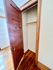 Charming wooden closet with ample storage space, featuring classic panel door and elegant hardwood flooring.
