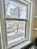 Charming city view from apartment window showcasing urban skyline and snowy streets.
