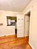Charming apartment interior featuring classic wooden flooring and a cozy kitchen with a checkered backsplash in view.