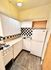 Charming kitchen with retro black and white checkered backsplash, white cabinets, and vintage gas stove.