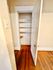 Cozy apartment showcasing a charming closet with wooden shelves and classic white door, emphasizing practical storage solutions.