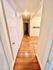 Charming apartment hallway with warm wooden floors and soft lighting, offering a cozy and inviting entrance.